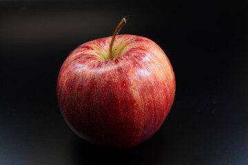 Reifer Apfel auf schwarzem Hintergrund bei Kunstlicht