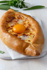Khachapuri in Adjarian or Adjara khachapuri, boat, national Georgian cuisine, pastry with cheese and egg.
