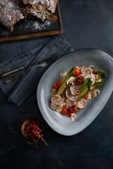 Close up on traditional italian cuisine Vitello tonnato. A dish with pickled veal with tuna cream sauce and bread on wooden background. Copy space for design, text. Snack before lunch. Close up food.