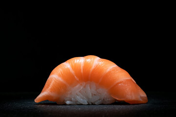 Classic sushi nigiri with salmon on a dark stone background, close up, copy space © Andrey