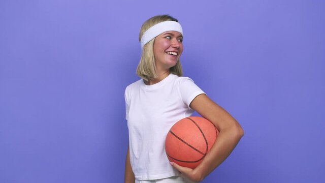 Young basketball player woman looks aside smiling, cheerful and pleasant