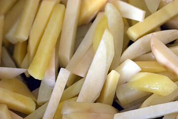 potatoes, cut into strips, in a frying pan