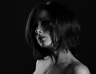 Alluring portrait of short bob hair style woman looking down on black background. Closeup art portrait.