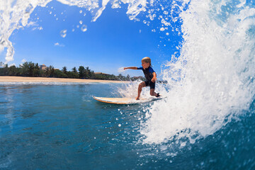 Happy surf boy - young surfer learn to ride on surfboard with fun on sea waves. Active family lifestyle, kids outdoor water sport lessons, swimming activity in surfing camp. Summer vacation with child - obrazy, fototapety, plakaty
