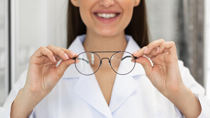 Closeup portrait of young woman showing spectacles