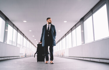 Fototapeta premium Pensive man in suit walking along airport hallway