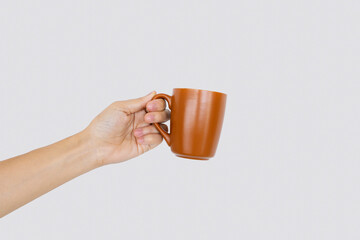closeup hand holding cup of coffee in white background with soft-focus and over light in the background