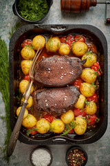 Delicious roasted goose breast served with vegetables, potatoes. Placed in metal baking dish