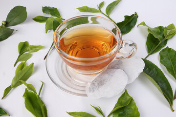 different types of fresh raw green tea leaf flower bud transparent glass teacup liquid tea bag on white background