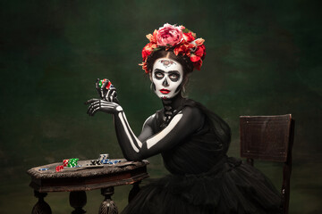 Gambling. Young girl like Santa Muerte Saint death or Sugar skull with bright make-up. Portrait...