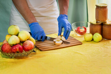 Man cuts off the peel of an apple. Conservation. Cooking apples. Saving apples for the winter.