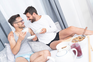 Gay male couple having bed tea