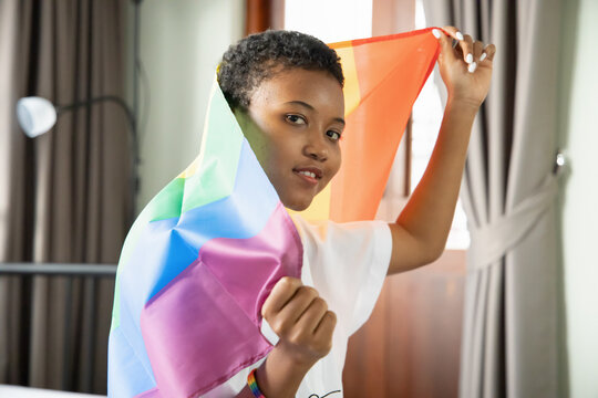 Black African LGBT Woman Holding LGBTQ Rainbow Flag, Lesbian Pride Or LGBT Pride Movement, Inclusivity, Diversity Of People Concept