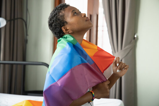 Black African LGBT woman holding LGBTQ rainbow flag, lesbian pride or LGBT pride movement, inclusivity, diversity of people concept