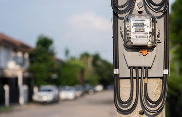 The electricity meter is located at the electric pole. Background blur in housing estate