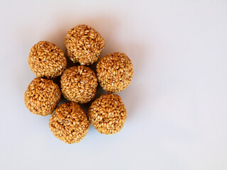 White sesame seed balls made with heated  jiggery against white background