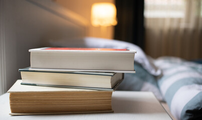 books on bedroom table by bed