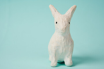Festive white rabbit toy on a blue background with pastel colors Easter