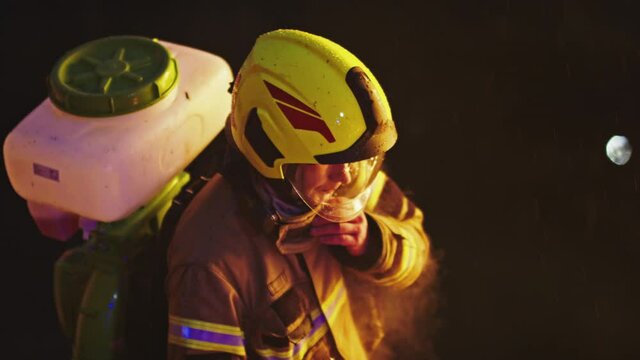 Firefighter with canister on his back in the night. HIgh angle. High quality 4k footage