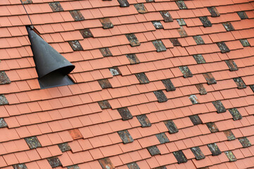 Dachdecker Handwerk: Dachziegel aus Terracotta oder Ton und runder Schornstein 