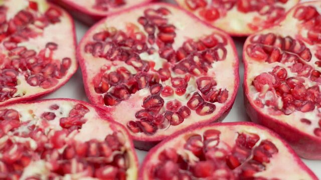 Sliced Fresh Slices Of Ripe Pomegranates. Isolated Background of Cut Pieces of Pomegranates. Pomegranate Slices, Close-up. Rotate.