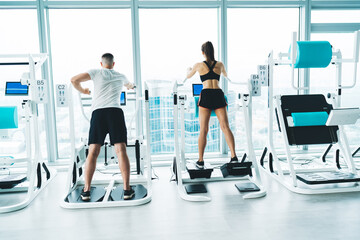 Sporty woman and man training in fitness club