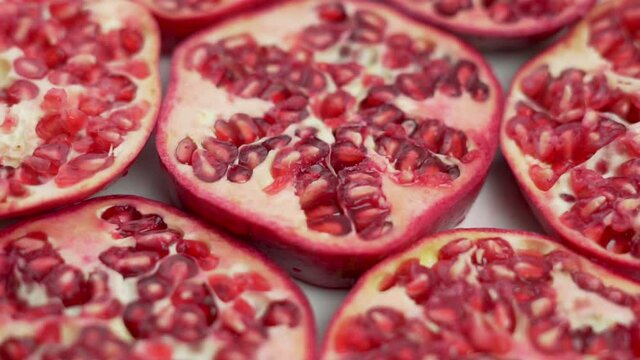 Fresh Juicy Pomegranate Slices Rotate, Isolated, Close-up. The Concept Of a Healthy Vegetarian Diet and a Vegan Vitamin Food.