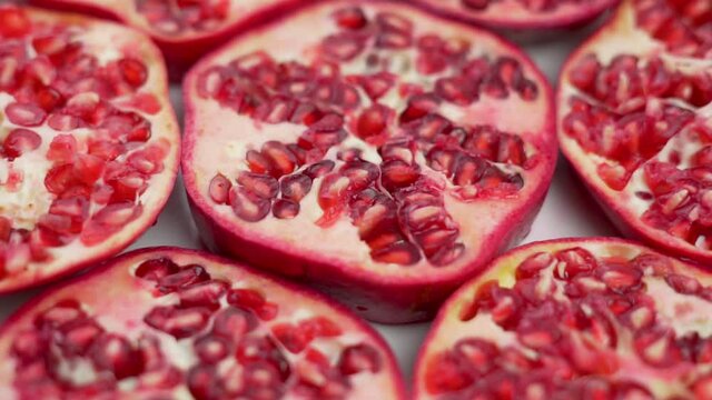 Juicy Fresh Pomegranate Pieces Rotate, Isolated, Close-up. Background of Pomegranate Slices. The Concept Of a Healthy Proper Nutrition and Vegetarian Vitamin Food.