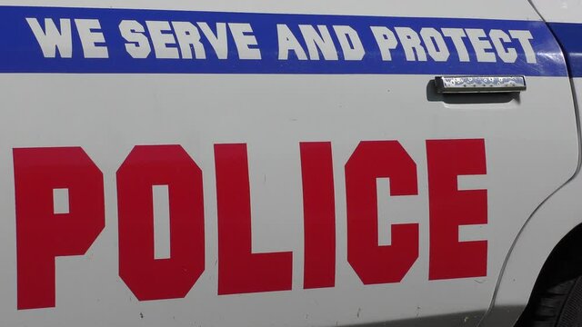 Police car with the words Protect and Serve. Actions by the police have resulted in calls to defund police departments.