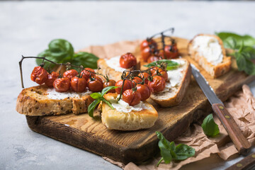 Tasty tapas, snack or crostini or Bruschetta with toasted baguette, roasted tomatoes. Delicious breakfast, snack, appetizers