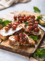 Tasty tapas, snack or crostini or Bruschetta with toasted baguette, roasted tomatoes. Delicious breakfast, snack, appetizers