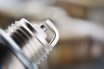 New and used spark plugs for internal combustion engine on metal background. Space for text