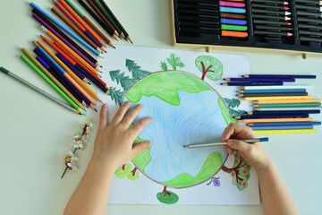 Child girl draws planet for earth day. Protection of enviroment, Save our planet. Concept of art learning and education, love earth , save world and unity.Ecology concept