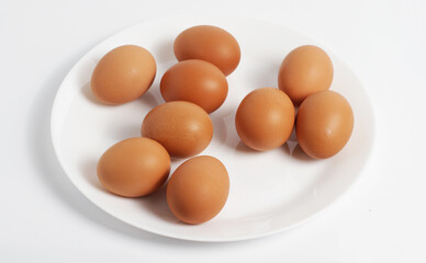 Composition Brown eggs on a plate. White background. Top view