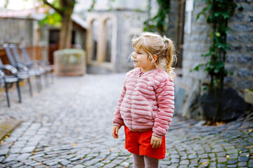 Portrait of adorable cute toddler girl of three years. Beautiful baby with blond hairs looking and smiling at the camera. Happy healthy child.