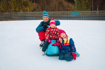 happy father with kids skating in winter