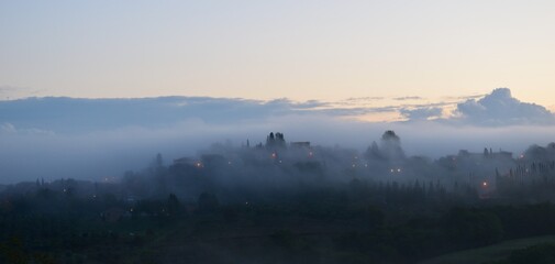 Fototapeta na wymiar village in the fog in Tuscany