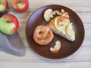Baked apple with honey, a piece of homemade apple pie in a plate and fresh apples with a napkin on...