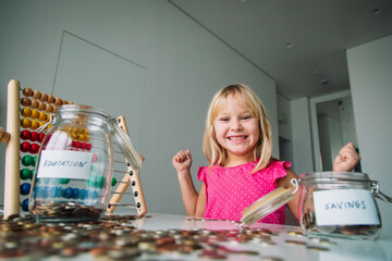 happy cute girl saving money, kid counting coins