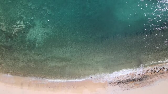 Overhead drone clp of waves crushing to the shore in Kavala, Macedonia, Greece