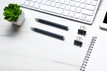 White desk office with laptop, smartphone and other work supplies with cup of coffee. Top view with copy space for input the text. Designer workspace on desk table essential elements on flat lay