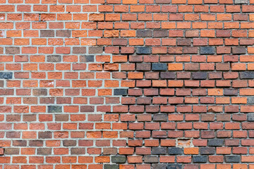 Texture of the restored wall of an old building. Smeared brickwork seams. Before and after renovation.