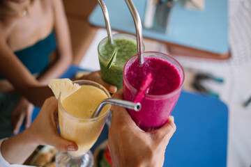 Crop anonymous people with colorful healthy smoothies