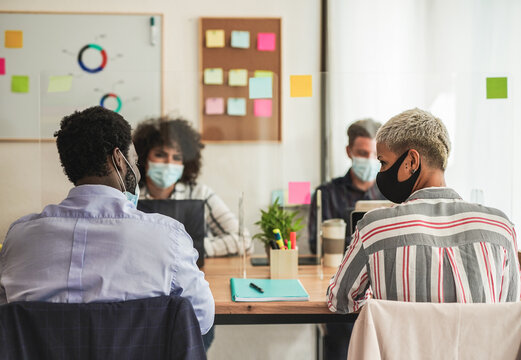 Multiracial staff in office working with safety measures for coronavirus - Concept of health care and coworking - Powered by Adobe