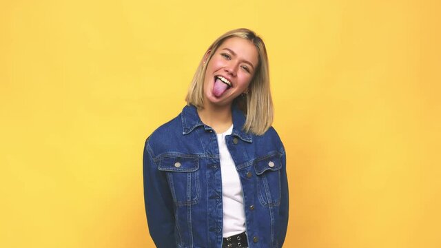 Young blonde caucasian woman funny and friendly sticking out tongue