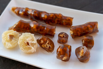 Cevizli sucuk made by dipping a string with walnuts into a grape molasses mixture. Churchkhela,...
