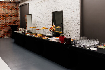 Tasty food and drink on black table for event