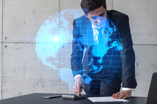 Businessman in office signs contract and world map hologram. Double exposure. Formal wear. International business connection. - Powered by Adobe