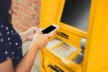 People using mobile smart phone to order withdraw money through ATM machines instead of ATM cash card. - obrazy, fototapety, plakaty