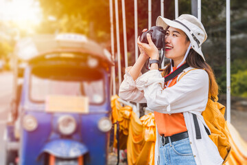 Asian tourists from Southeast Asia travel and photograph with tuktuk in Chiang mai, Thailand.